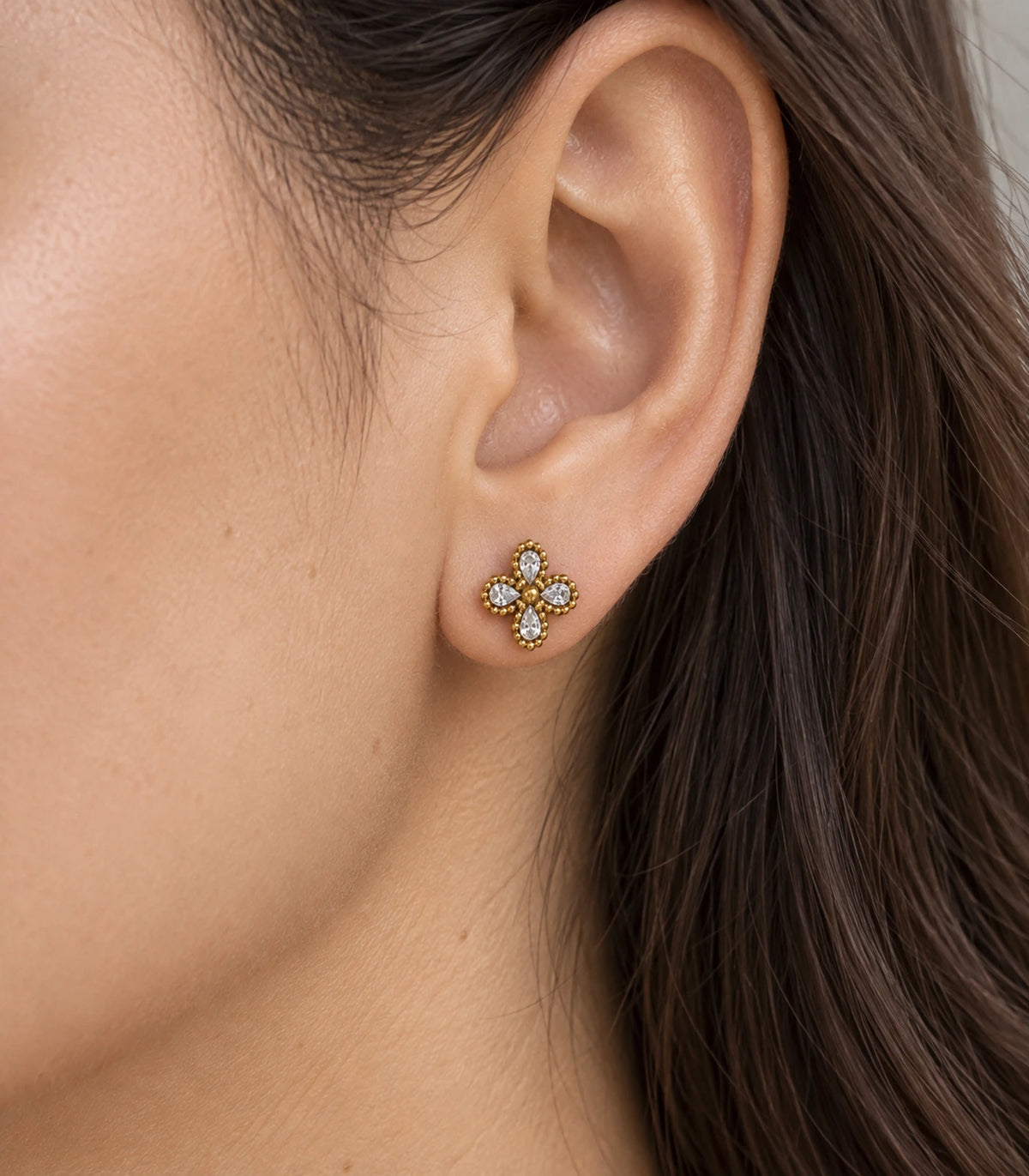 JIMIKI Antique Gold Crystal Clover Stud Earrings, worn close-up showing clear accents and gold-tone setting #color_antique gold
