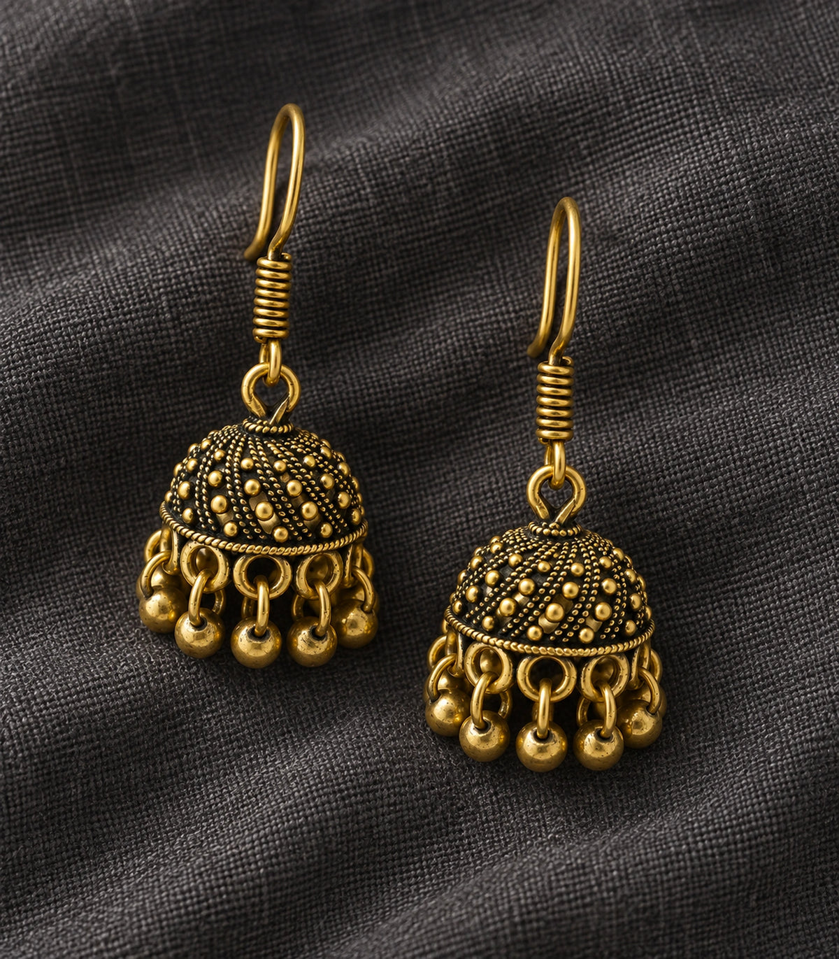 JIMIKI Antique Gold Dotted Swirl Mini Jhumka Earrings - styled flatlay of the matching earrings #color_antique-gold