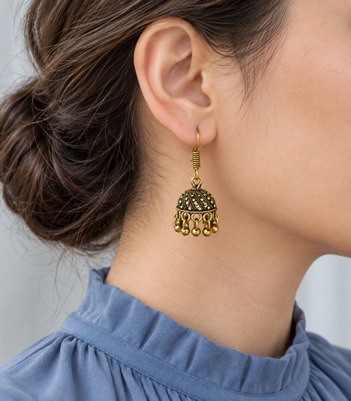 JIMIKI Antique Gold Dotted Swirl Mini Jhumka Earrings - styled model wearing the earring #color_antique-gold