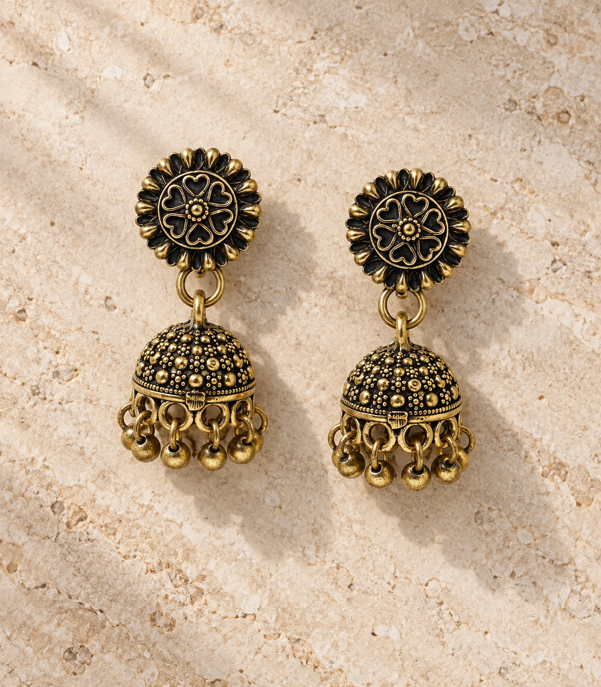 JIMIKI Antique Gold Heart Flower Stud Dotted Jhumka Earrings in Antique Gold - editorial flatlay #color_antique-gold