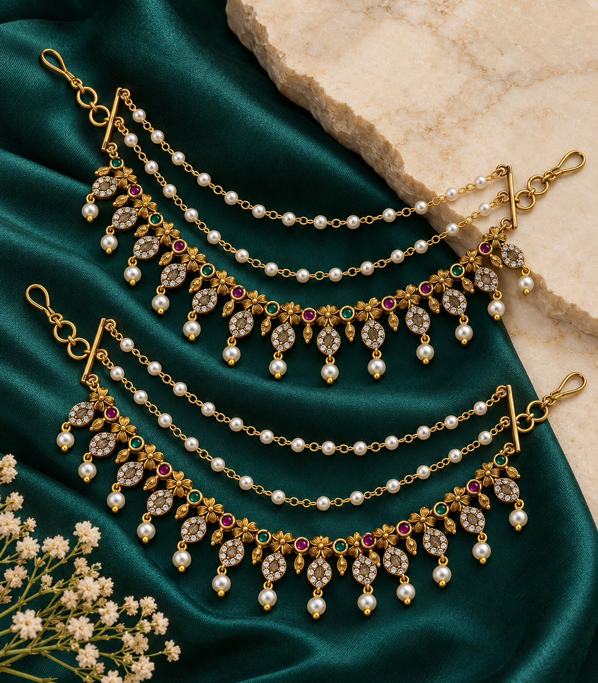 Antique gold tone flower oval pearl ear chain pair arranged on emerald silk and stone