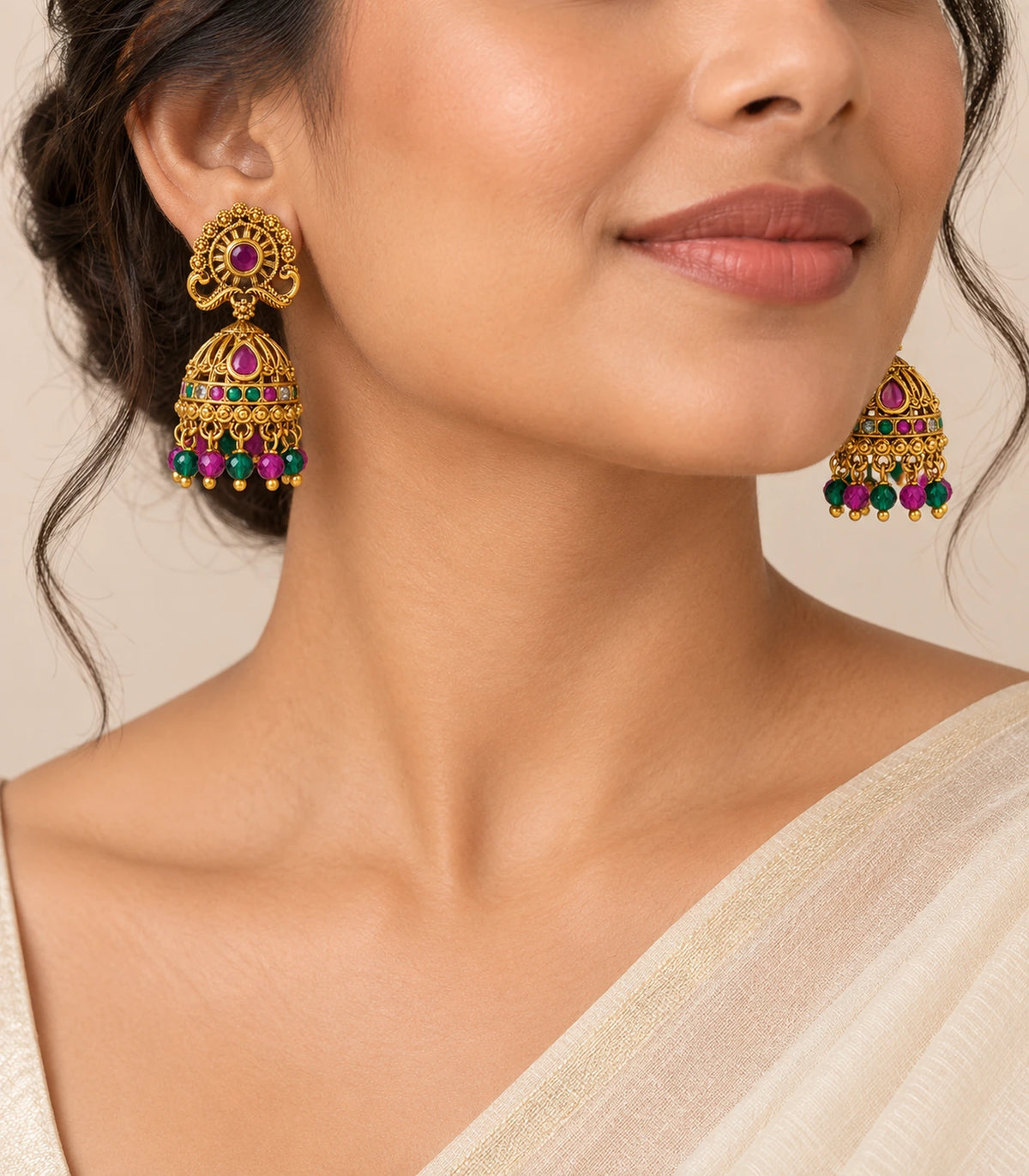 Antique gold tone magenta and green peacock jhumka earrings worn as a matching pair