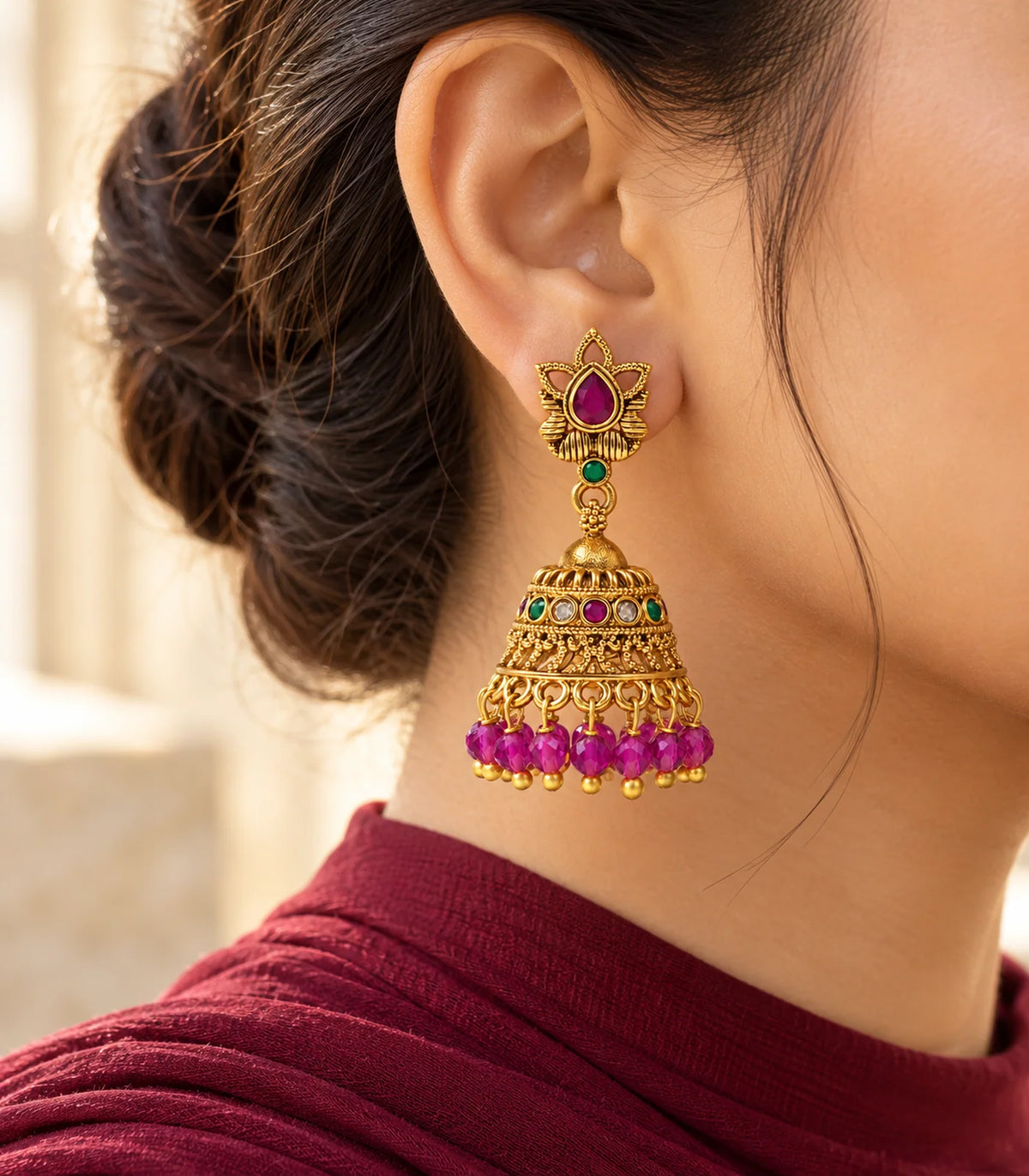 Magenta lotus jhumka earrings styled with hair up and a cream outfit