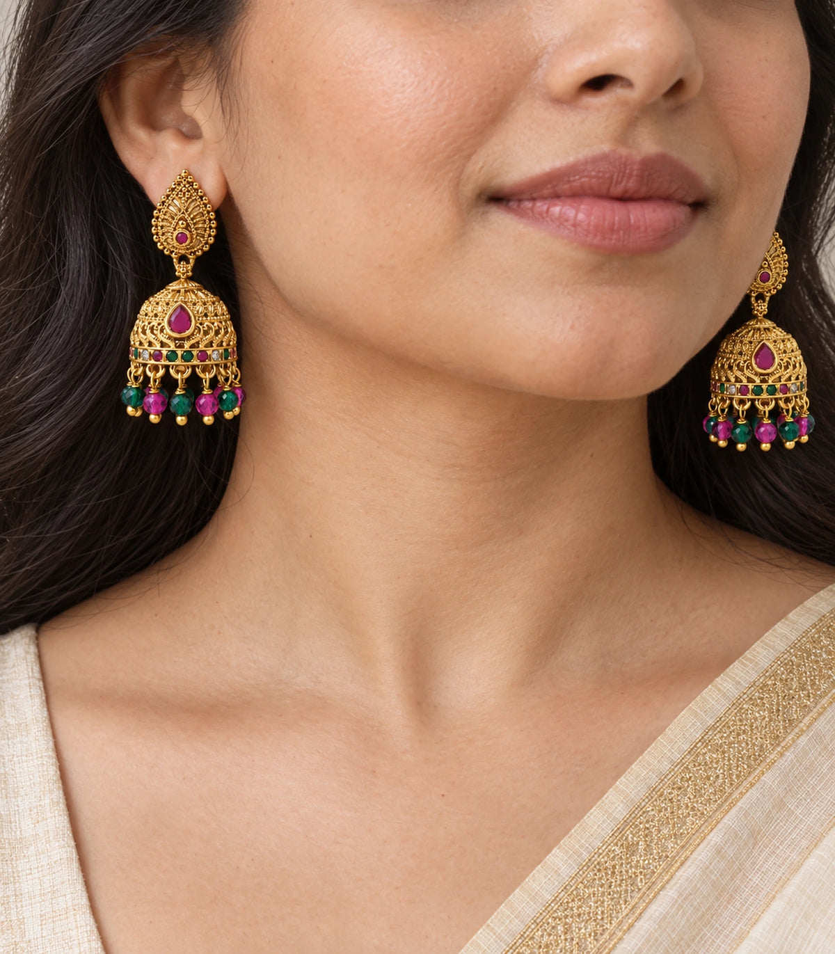 Close view of magenta teardrop accents and multicolour beaded jhumka earrings worn at the ears