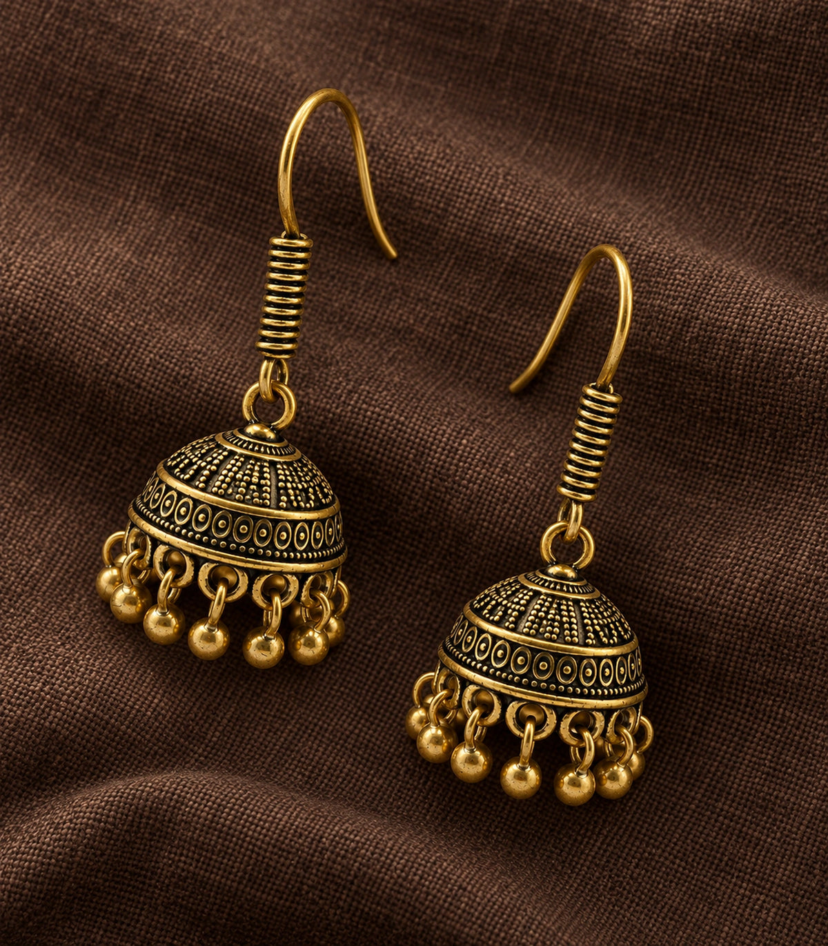 JIMIKI Antique Gold Oval Band Jhumka Earrings - styled flatlay of the matching earrings #color_antique-gold