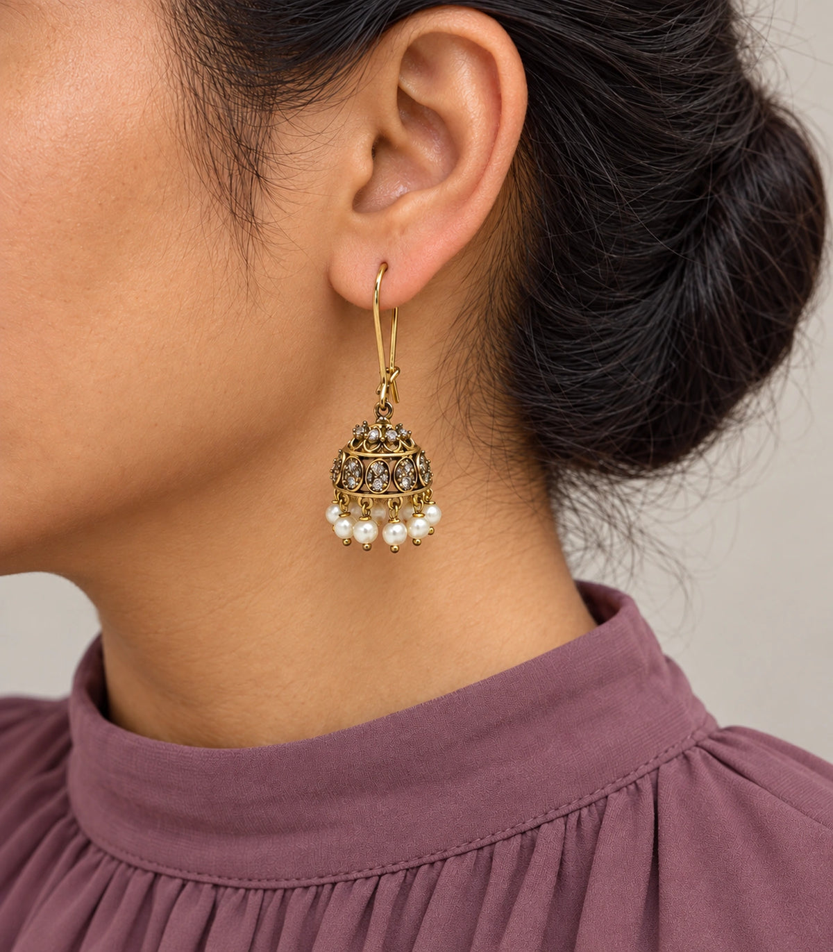 JIMIKI Antique Gold Oval Crystal Pearl Kidney Wire Jhumka Earrings - Worn styling view #color_antique-gold