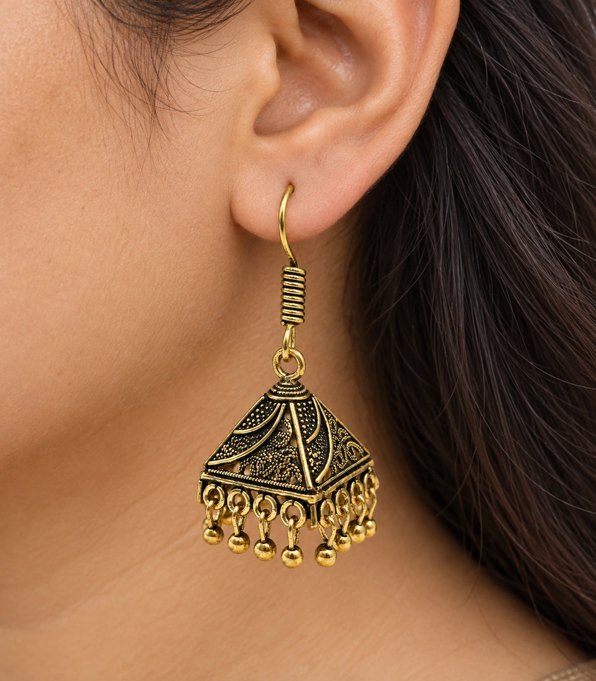 JIMIKI Antique Gold Paisley Pyramid Jhumka Earrings - close-up of the earring worn #color_antique-gold