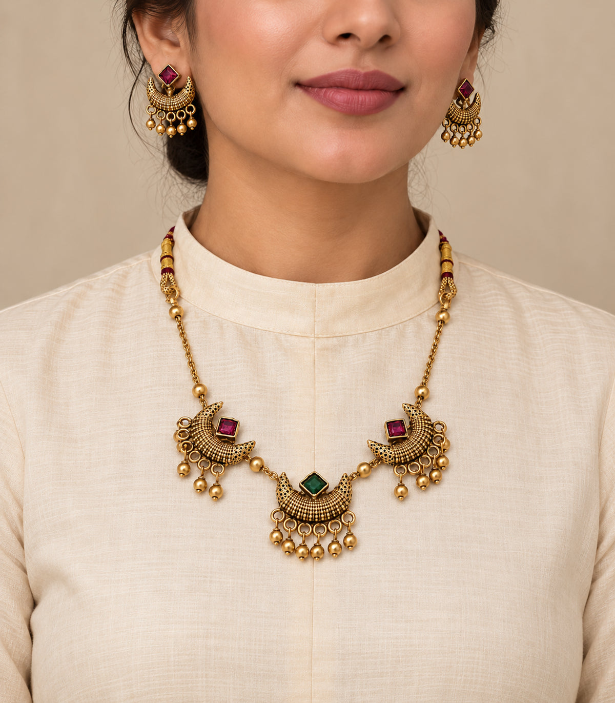 Antique gold-tone magenta green crescent necklace set worn with ivory clothing