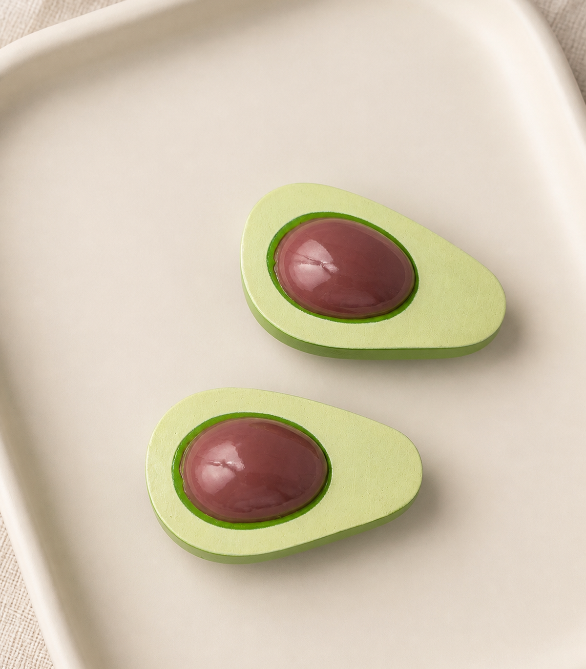 JIMIKI Elongated Avocado Slice Barrette Pair in Pale Green / Brown, editorial flat lay