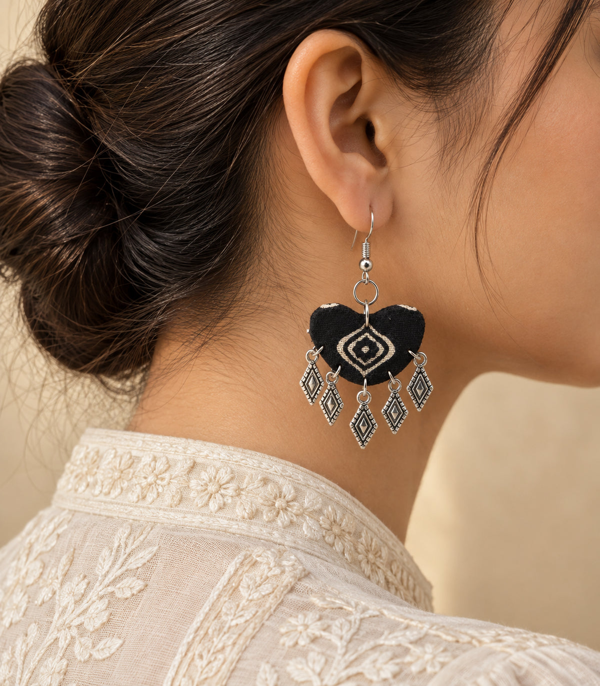 Black diamond-print fabric charm earring styled with ivory clothing