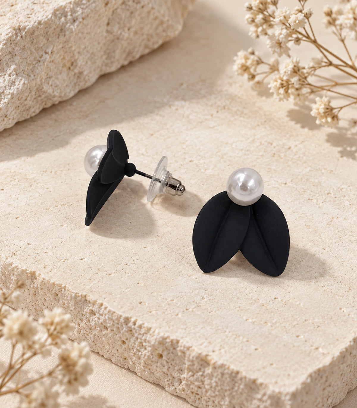 JIMIKI Double Leaf Pearl Stud Earrings in Black — pair in a styled flat lay #color_black