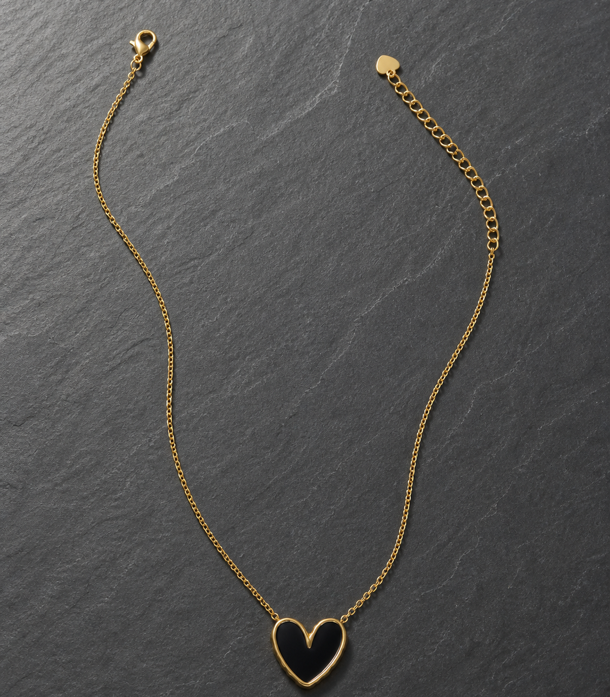 Black Heart Pendant Necklace in an editorial flat lay