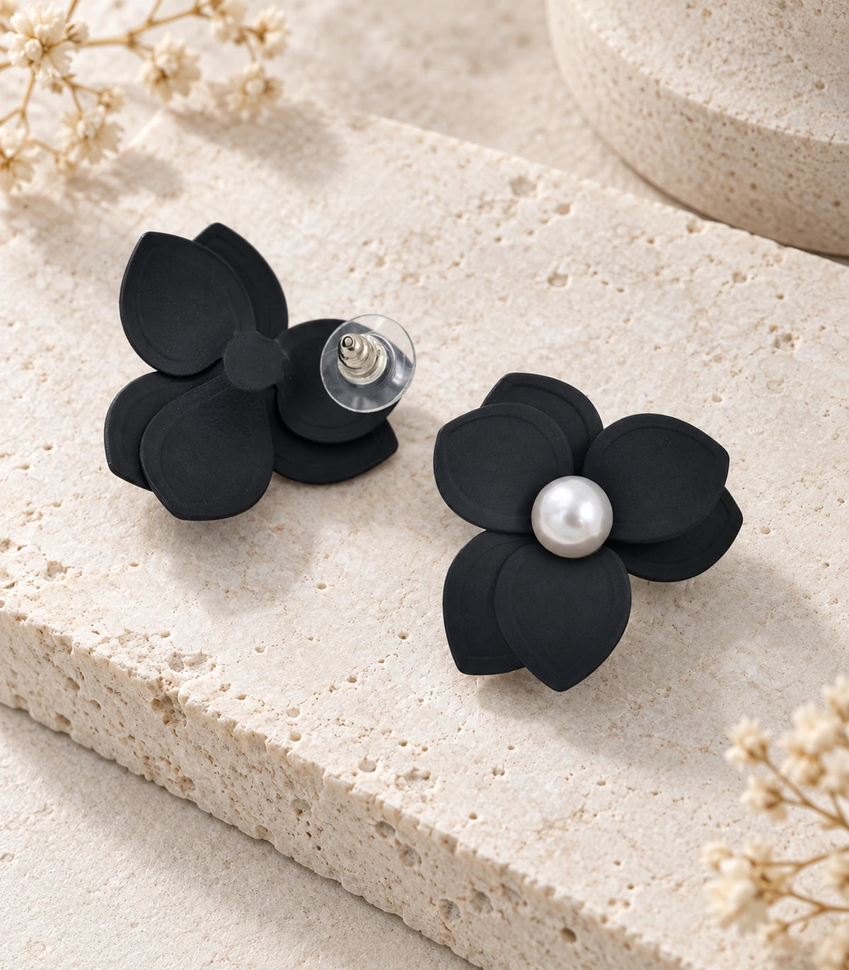 JIMIKI Black Triple Petal Pearl Flower Stud Earrings - pair in styled flat lay #color_black