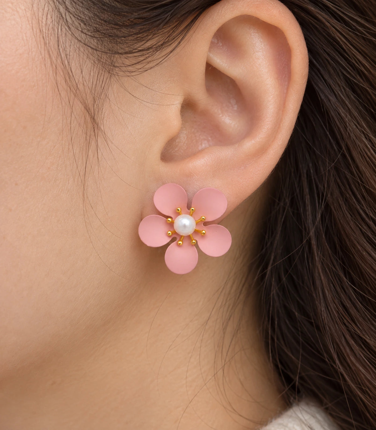 JIMIKI blush pink five-petal flower stud earrings with pearl-effect centre, closeup of flower stud in a natural worn setting #color_blush-pink