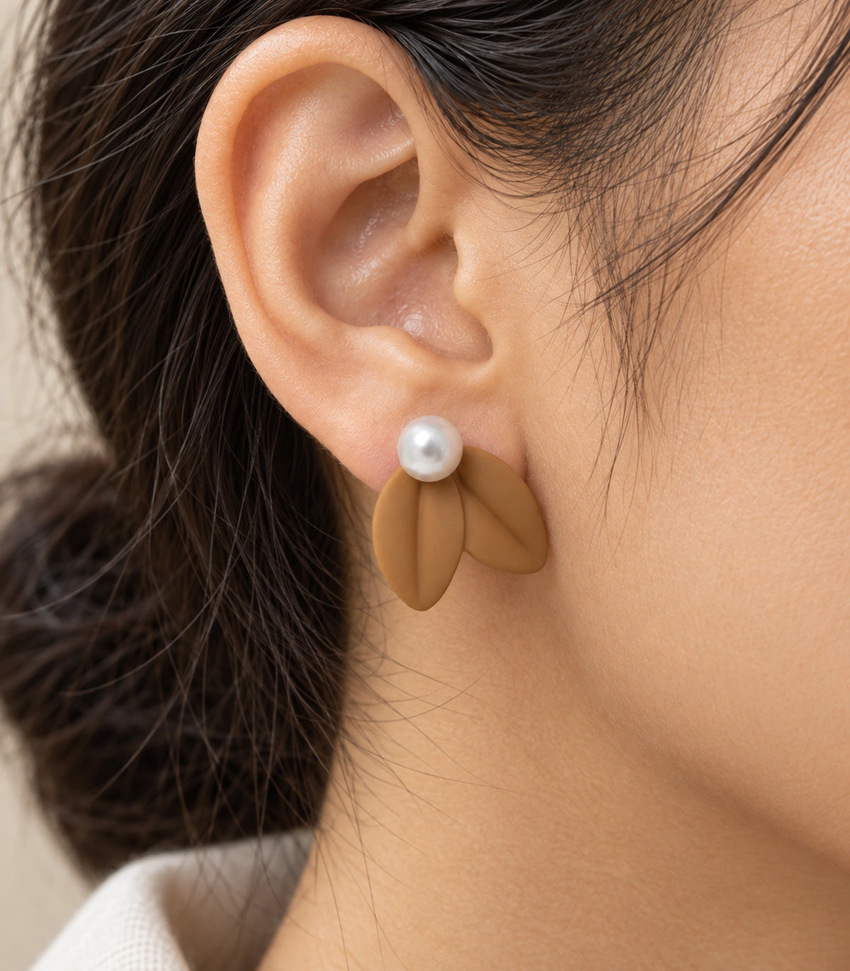 JIMIKI Double Leaf Pearl Stud Earrings in Camel — close-up of the earring worn on the ear #color_camel
