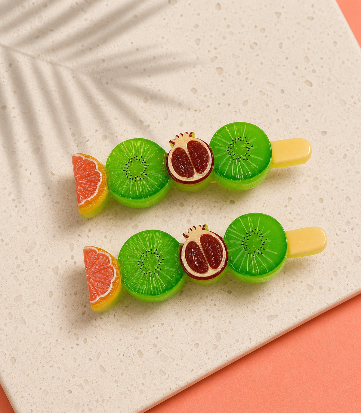 Citrus Kiwi Pomegranate Barrette Pair in an editorial flat lay