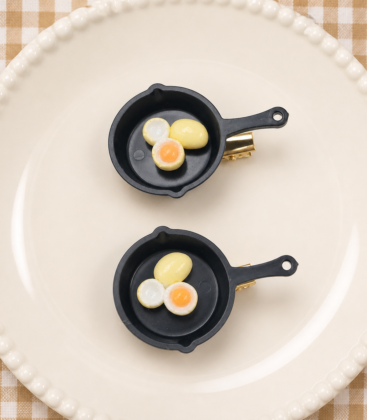 JIMIKI Egg Trio Frying Pan Barrette Pair in Black / Cream / Orange, editorial flat lay