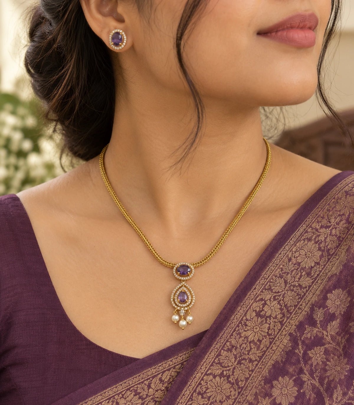 Gold-tone purple pendant necklace and matching oval stud earring worn with a purple outfit
