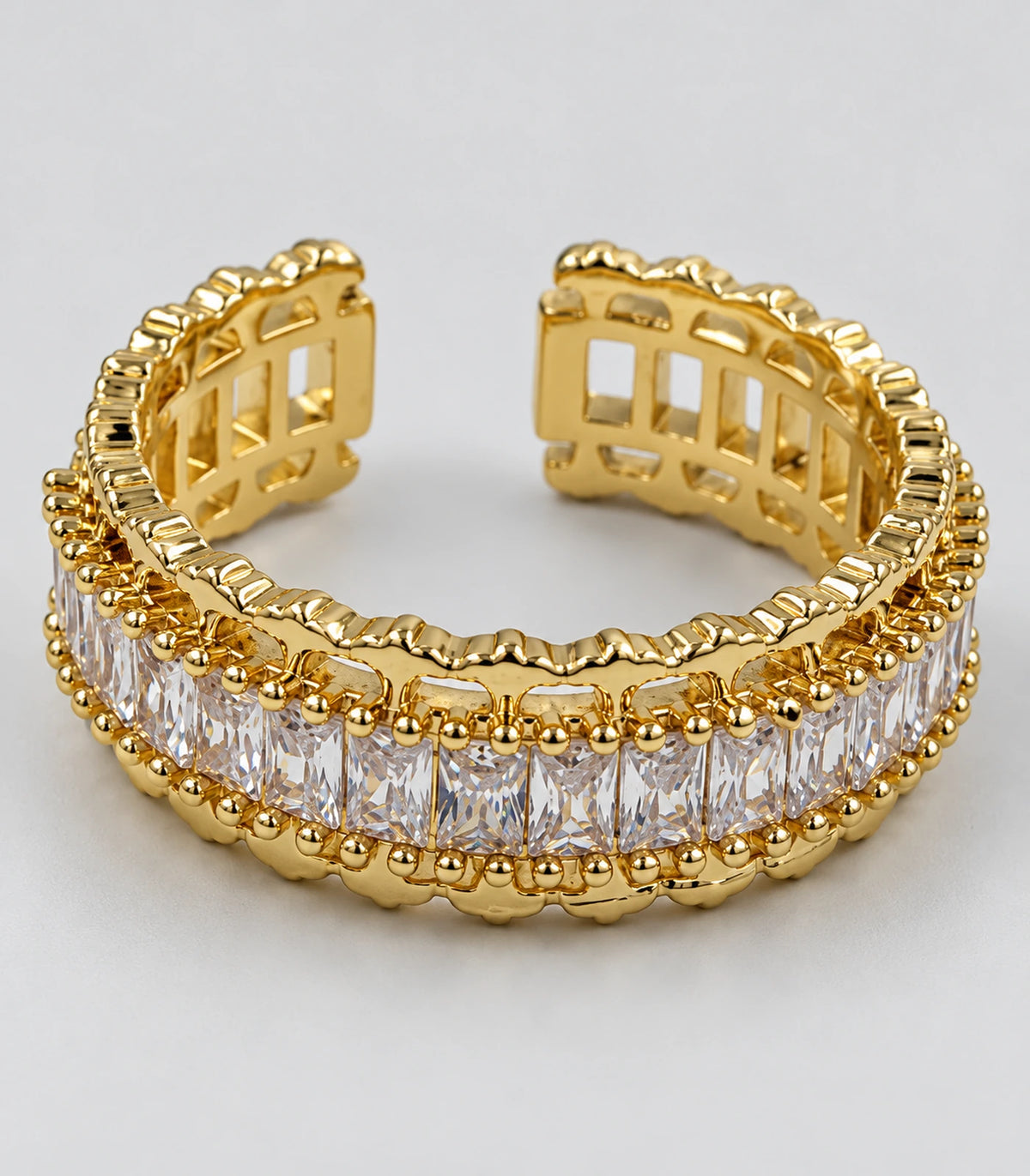 Detailed view of the clear rectangular stone row and gold-tone open gallery
