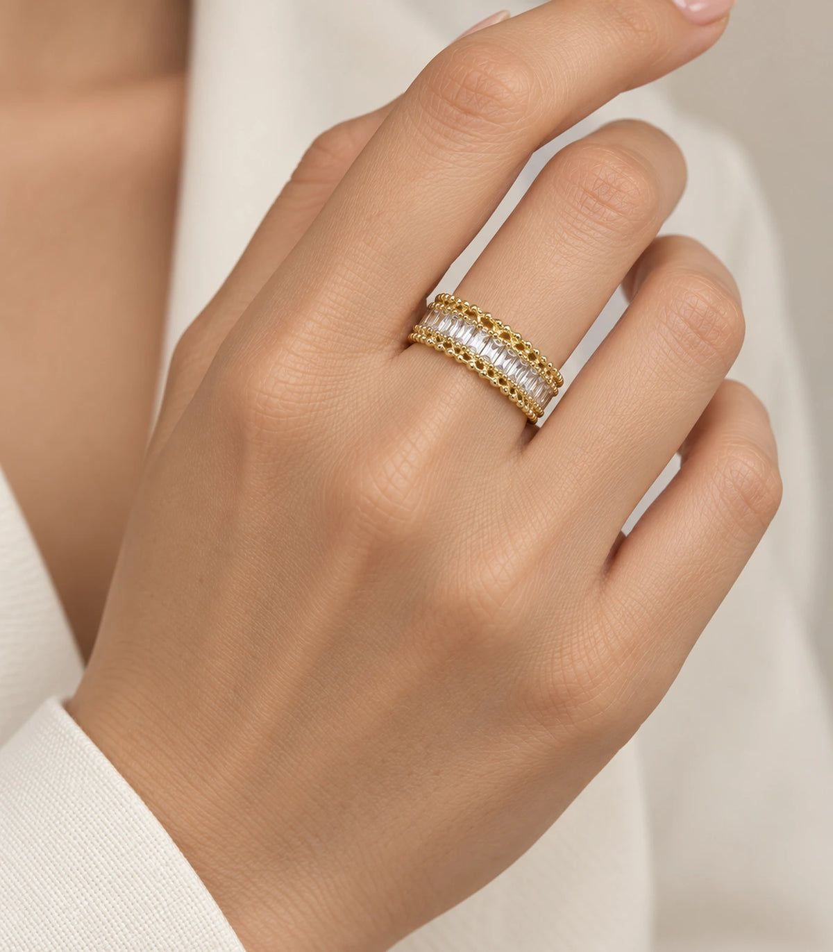 Gold-tone baguette-style ring worn naturally on a finger
