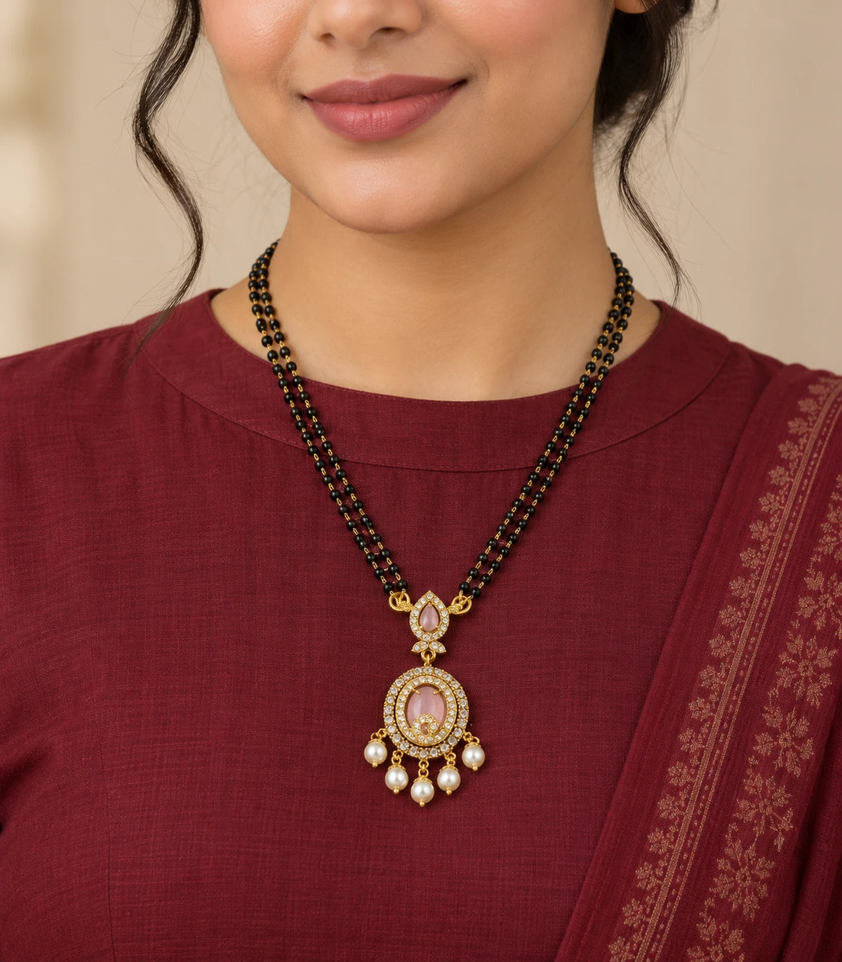 Blush pendant and five pearl drops worn on double black-bead strands with a burgundy outfit