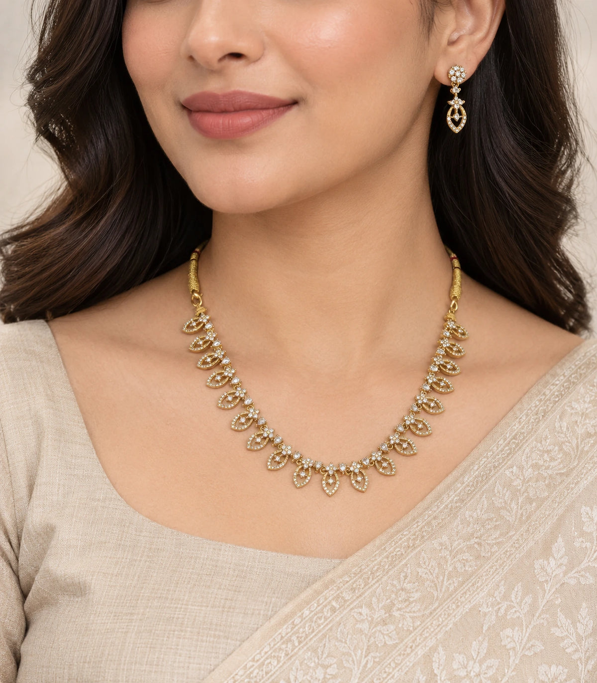 Gold-tone clear marquise necklace and matching drop earring worn with an ivory outfit