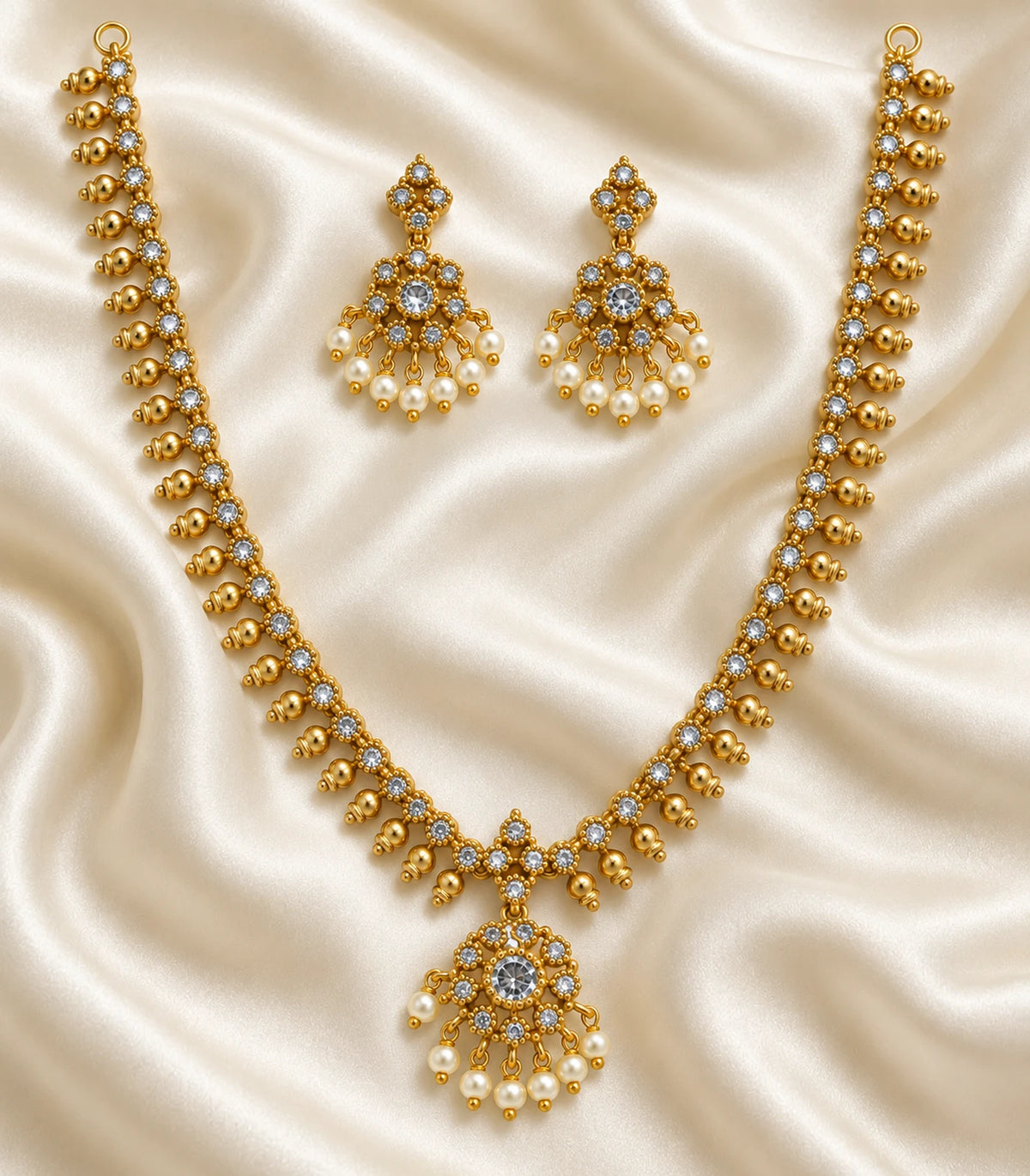 Gold Clear Round Pearl Fringe Pendant Necklace Set with matching earrings arranged on ivory fabric