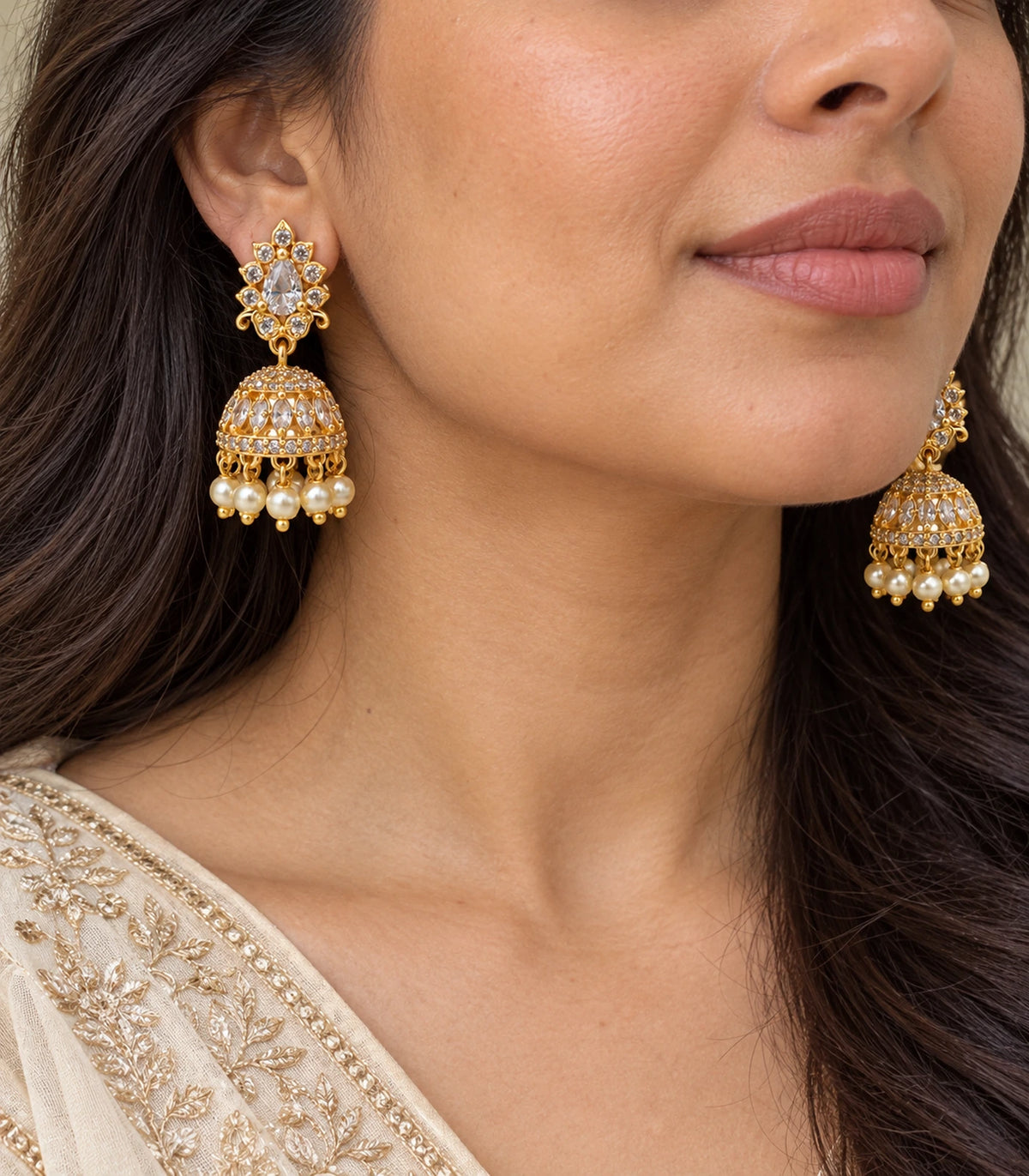 Close-up of clear teardrop floral jhumka earring and pearl-like drops