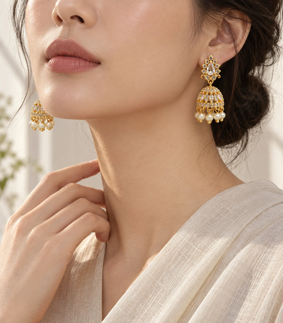 Editorial model view of gold-tone clear teardrop floral jhumka earrings