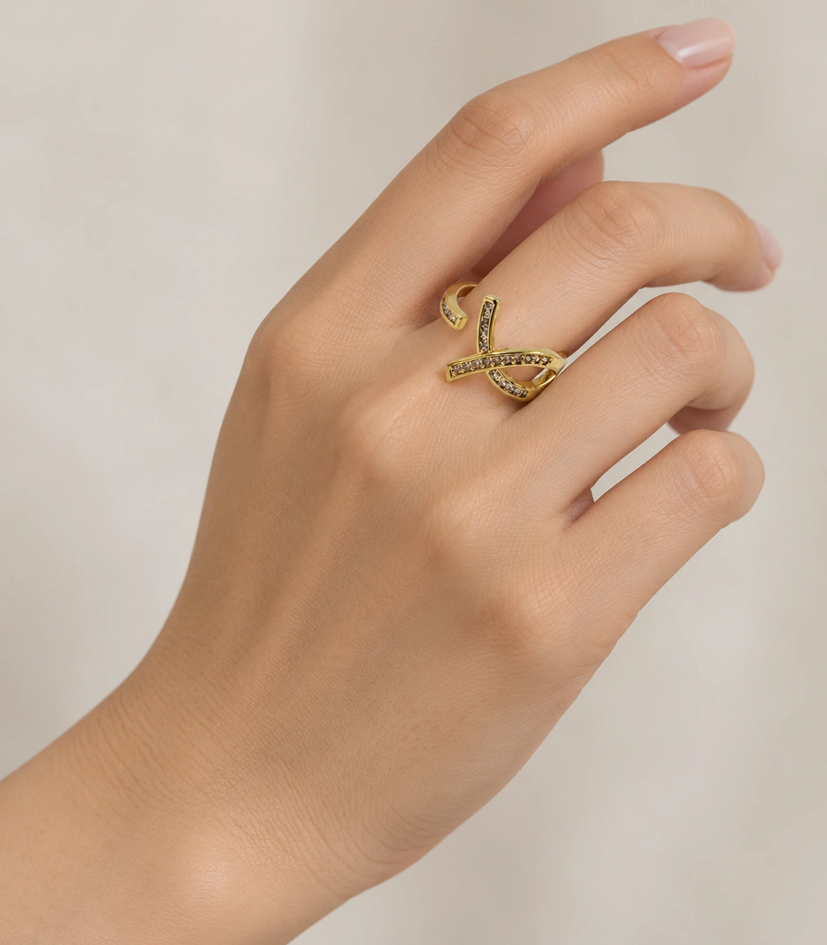 Gold Crystal Crossing Ribbon Open Ring worn on a hand