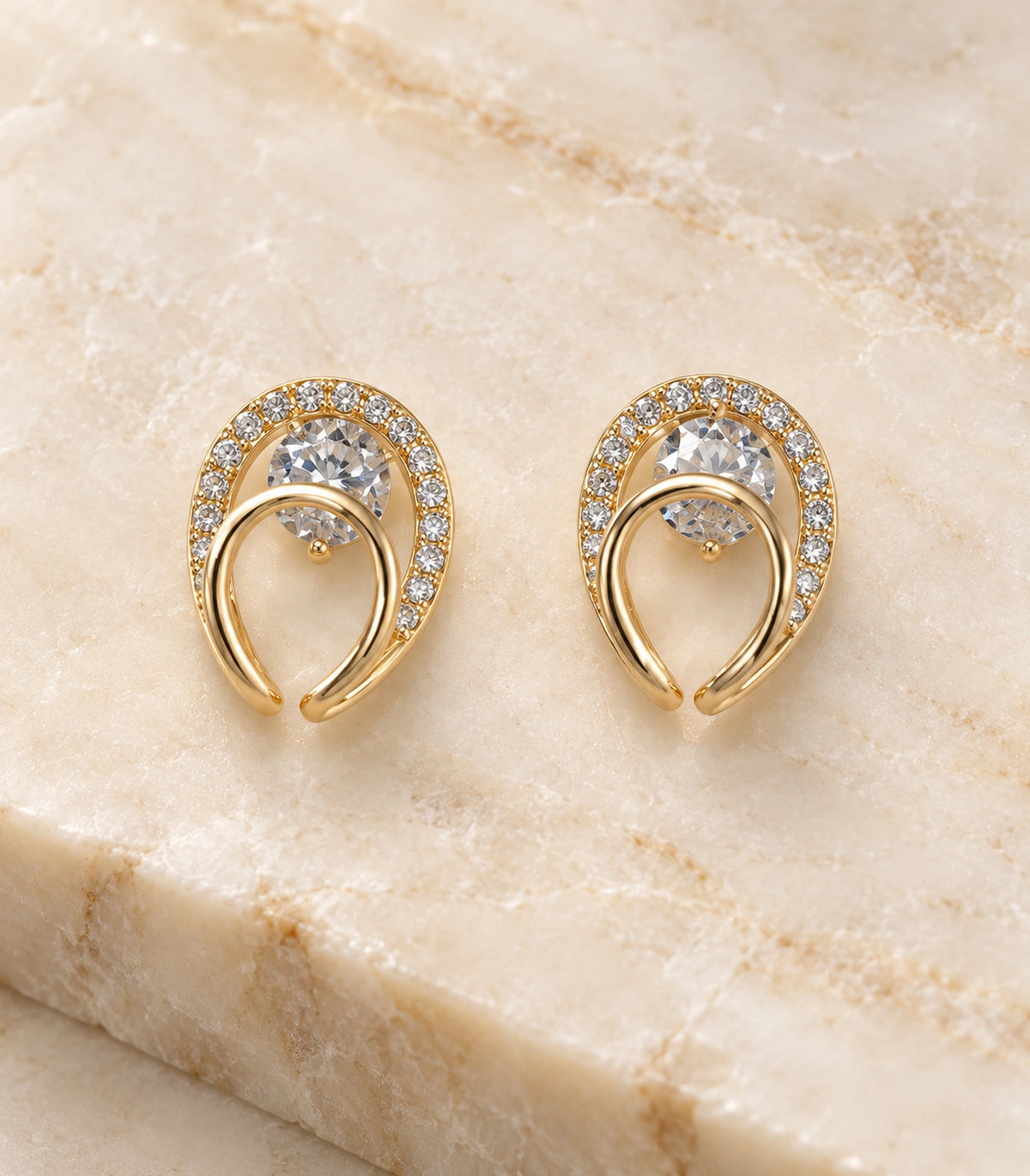 Close detail of the matching gold-tone double-loop earring pair on stone