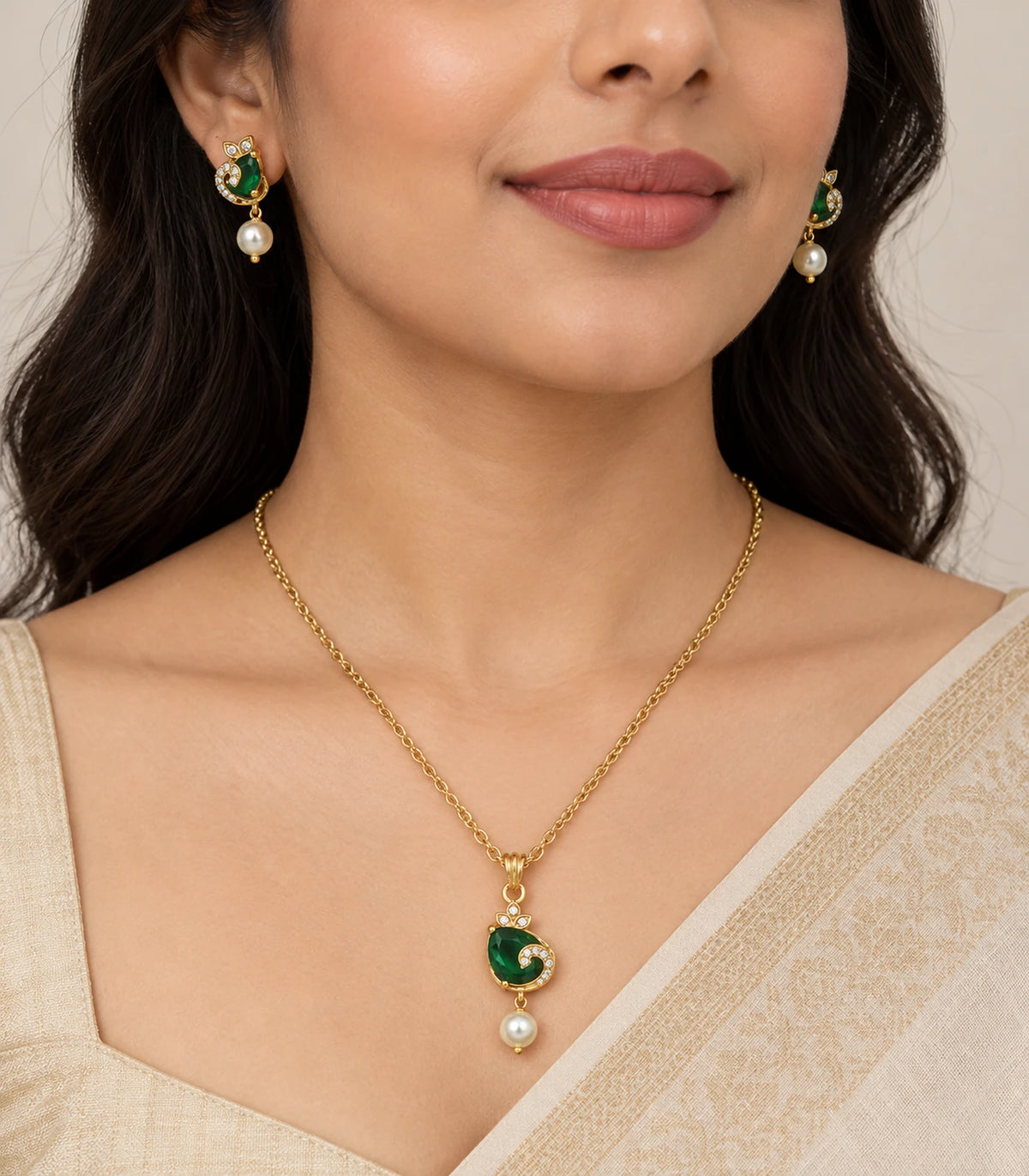 Emerald-green crescent pendant necklace set with matching earrings worn with a cream outfit