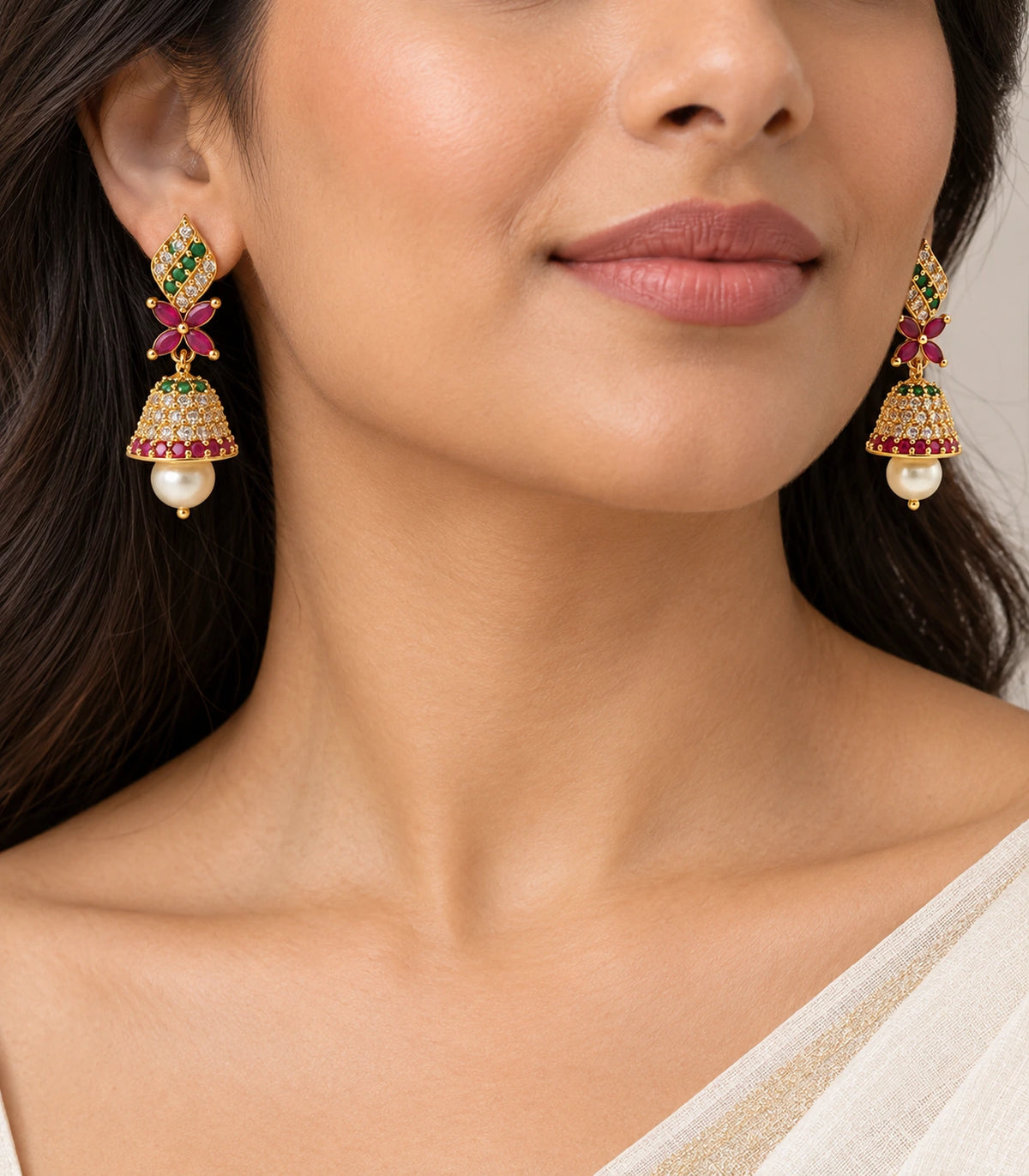 Gold-tone green and magenta butterfly jhumka earring pair worn with an ivory sari