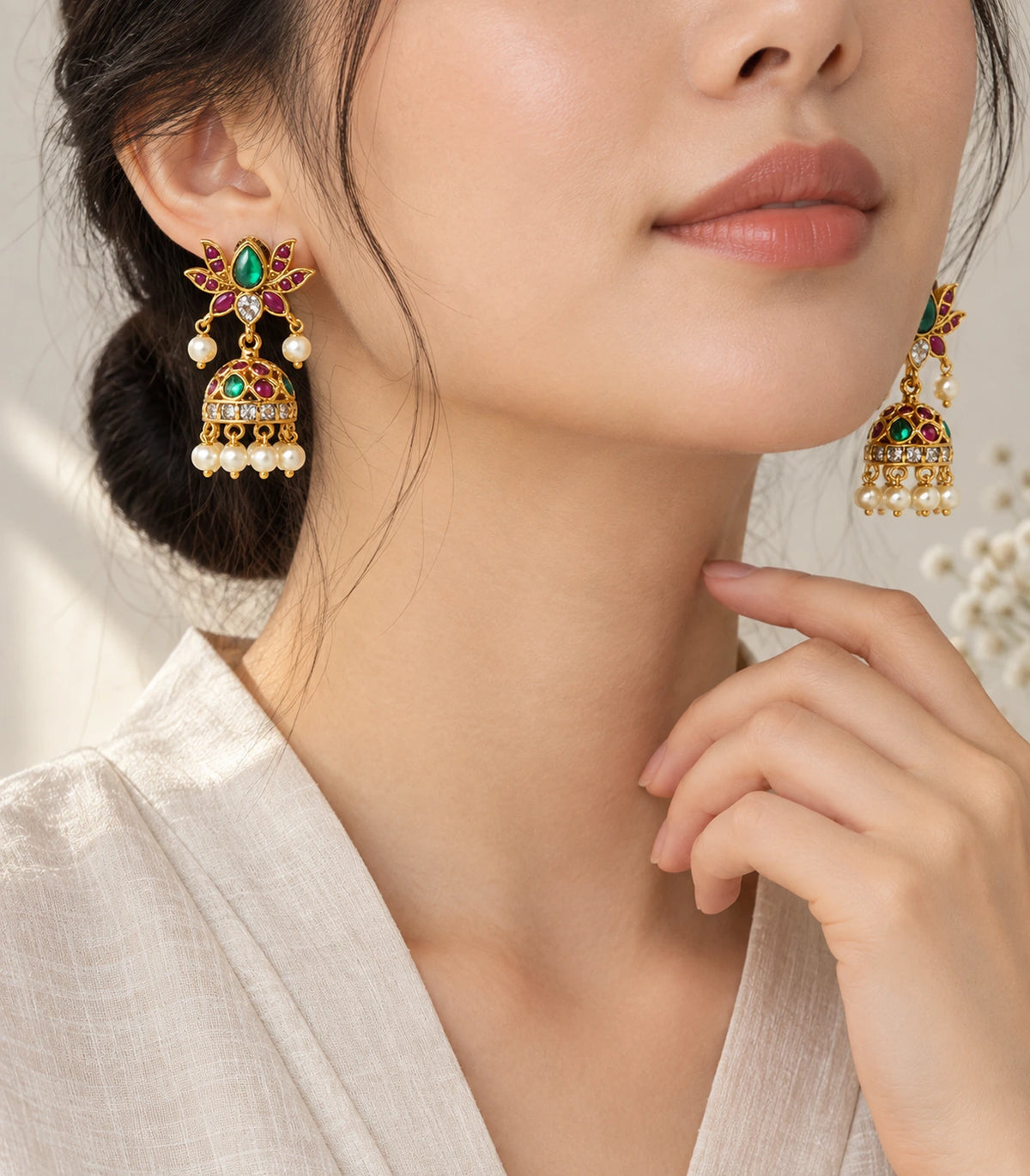 Gold green and magenta lotus jhumka earrings worn with an updo