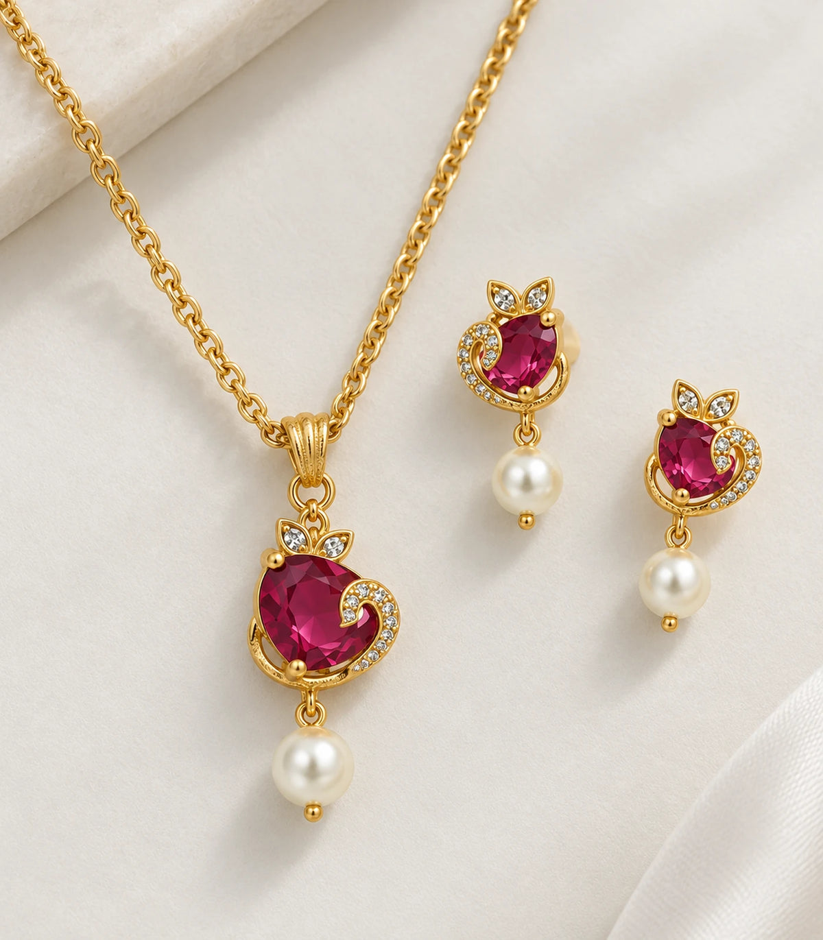 Detail of magenta centres, crescent accents and pearl drops on necklace and two earrings