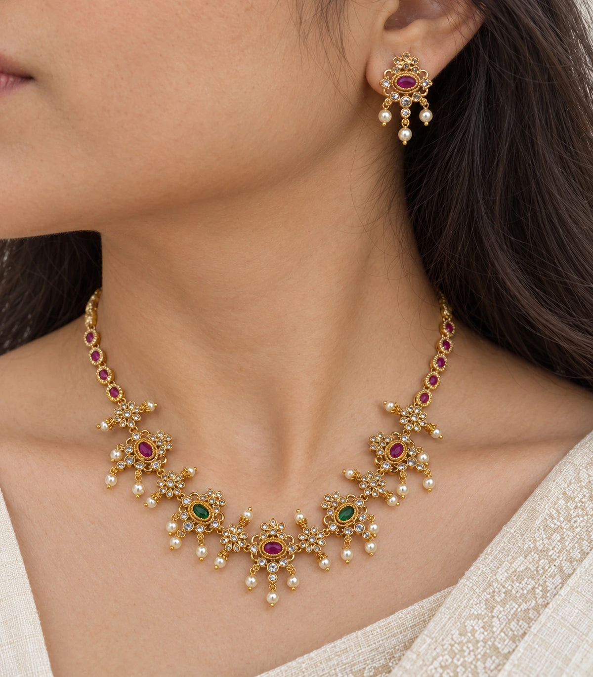 Close-up of the magenta and green floral necklace and matching earring in a worn setting