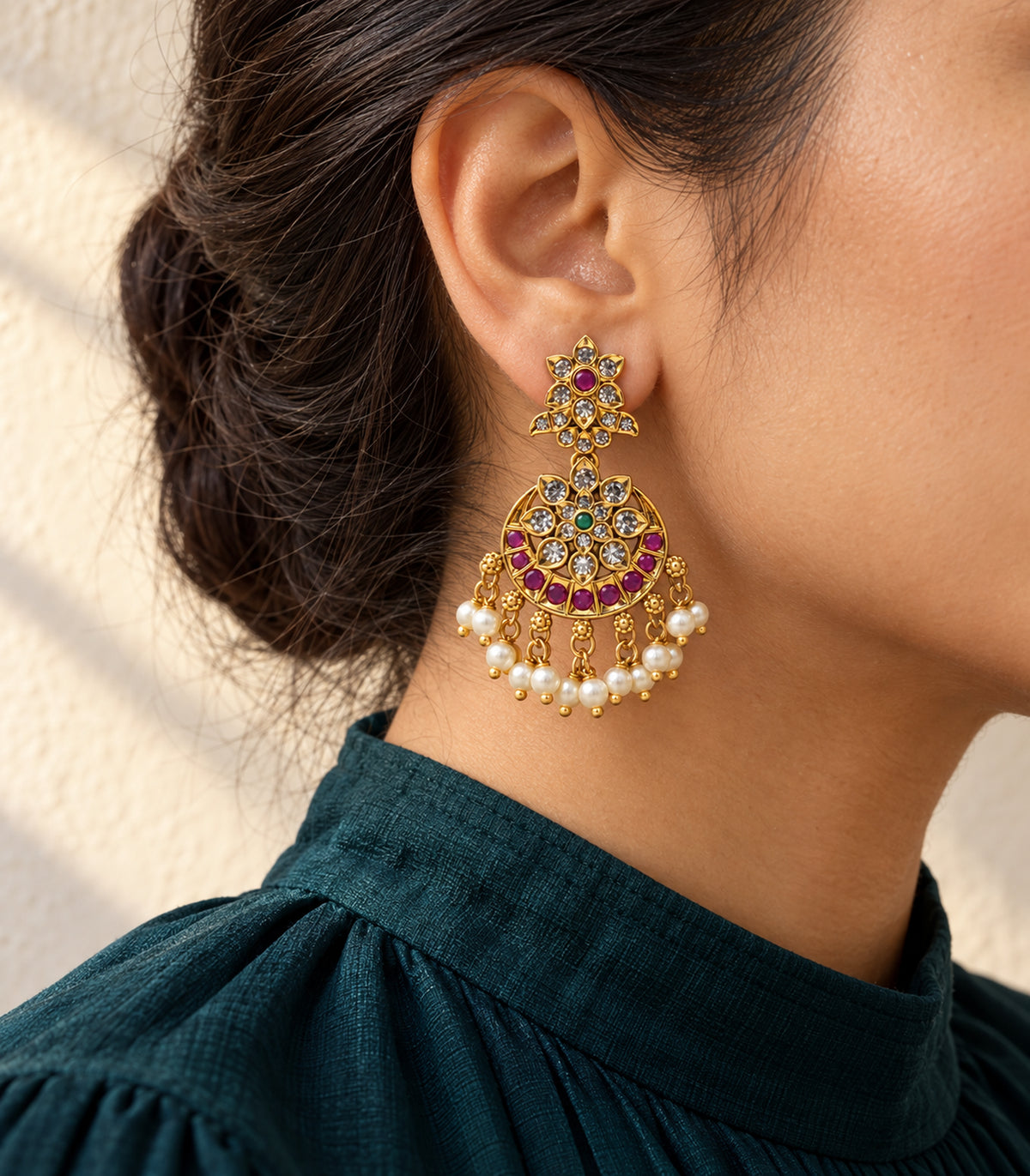 Gold, magenta and green floral pearl chandbali earring in an editorial worn view