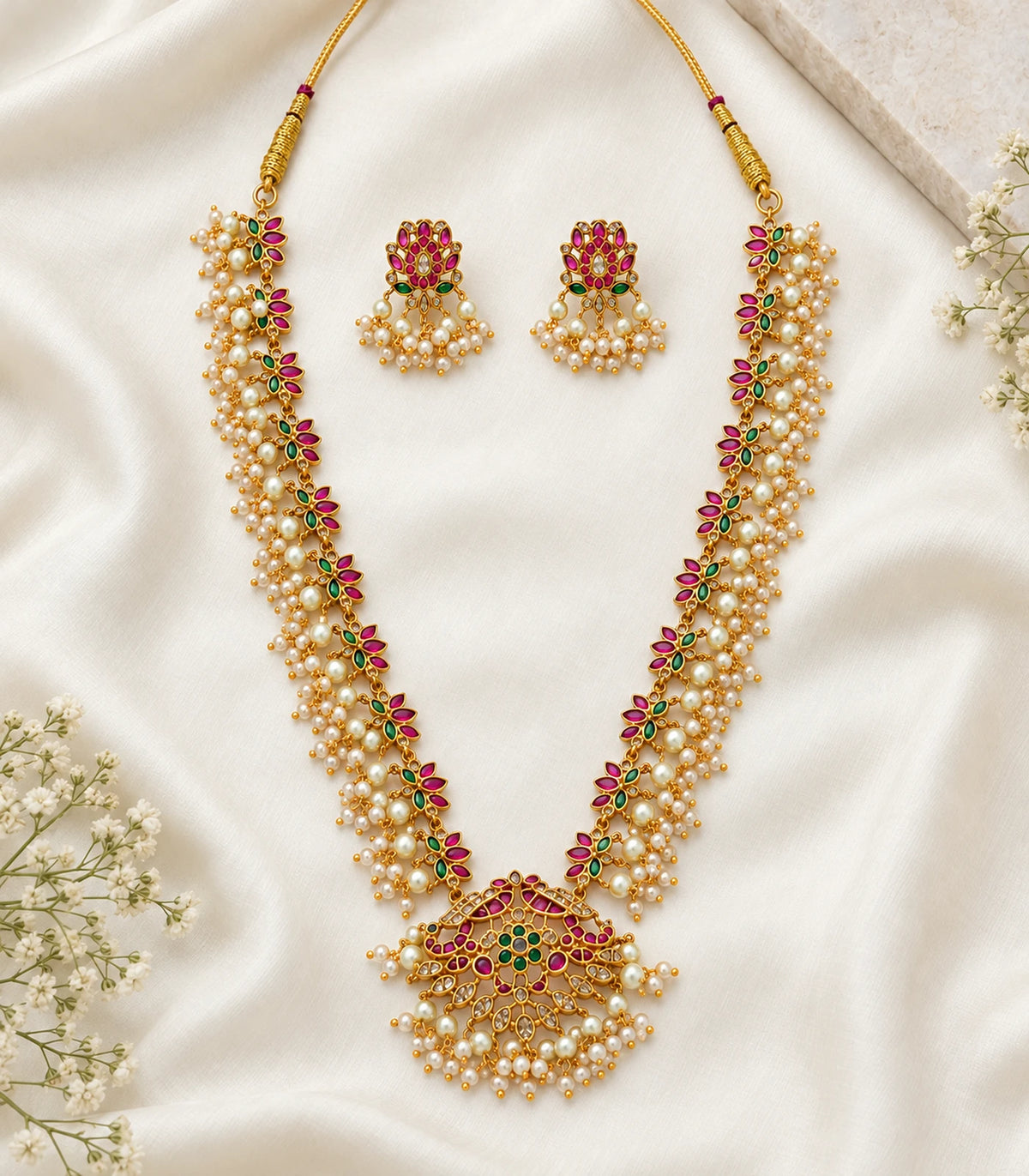 Gold Multicolor Pearl Fringe Necklace Set and matching earrings arranged on cream fabric