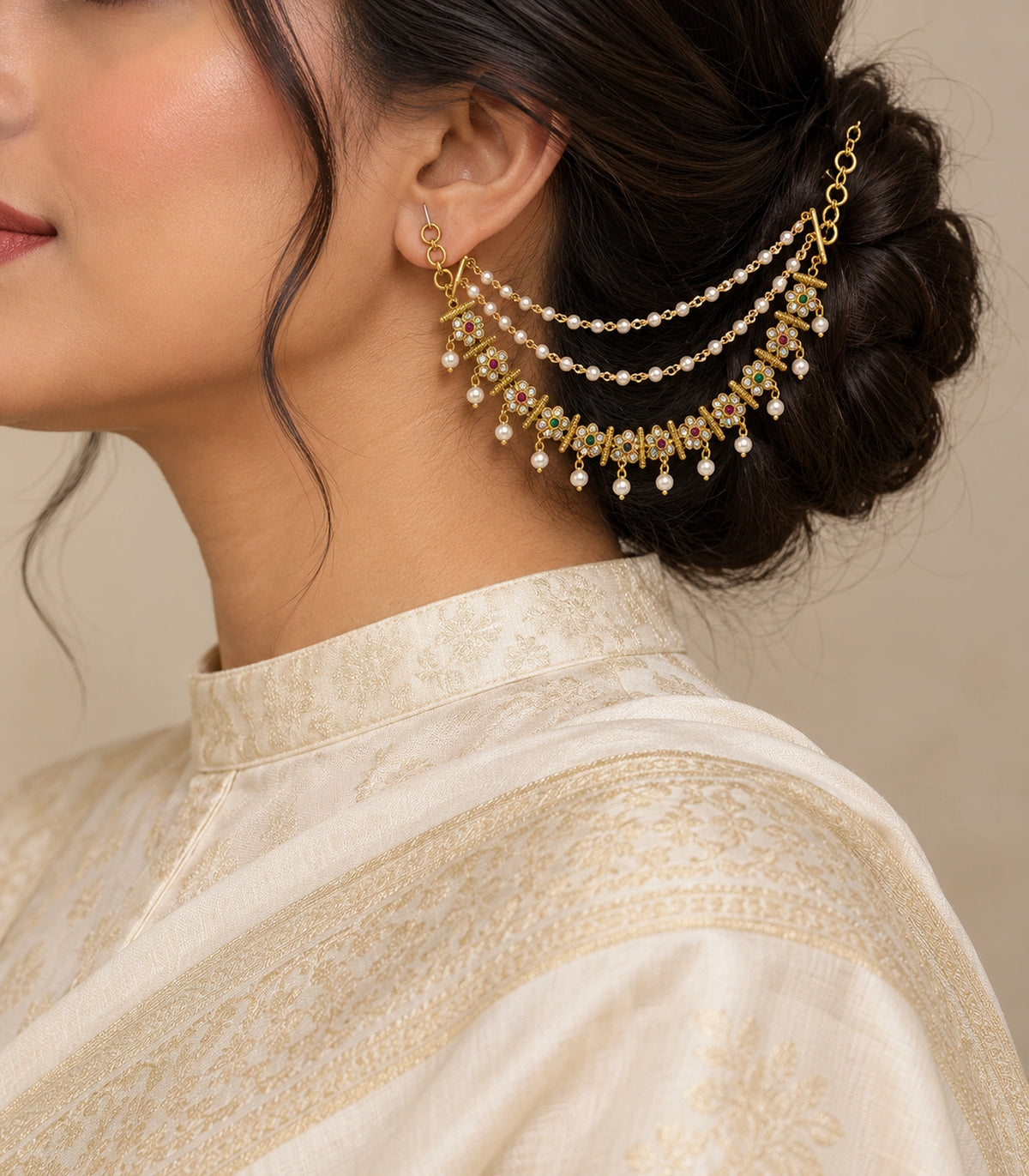 Gold tone magenta and green six-petal pearl ear chain worn with a modest ivory silk outfit