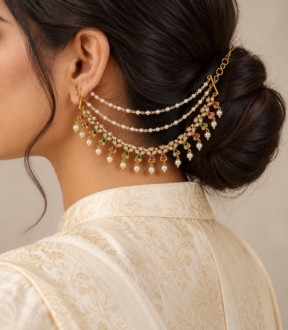 Gold tone magenta green triple-leaf pearl ear chain worn with a modest ivory silk outfit
