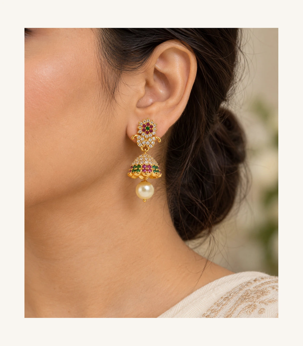 Single magenta and green gold-tone earring worn at the ear with floral top, dome and cream pearl-like drop