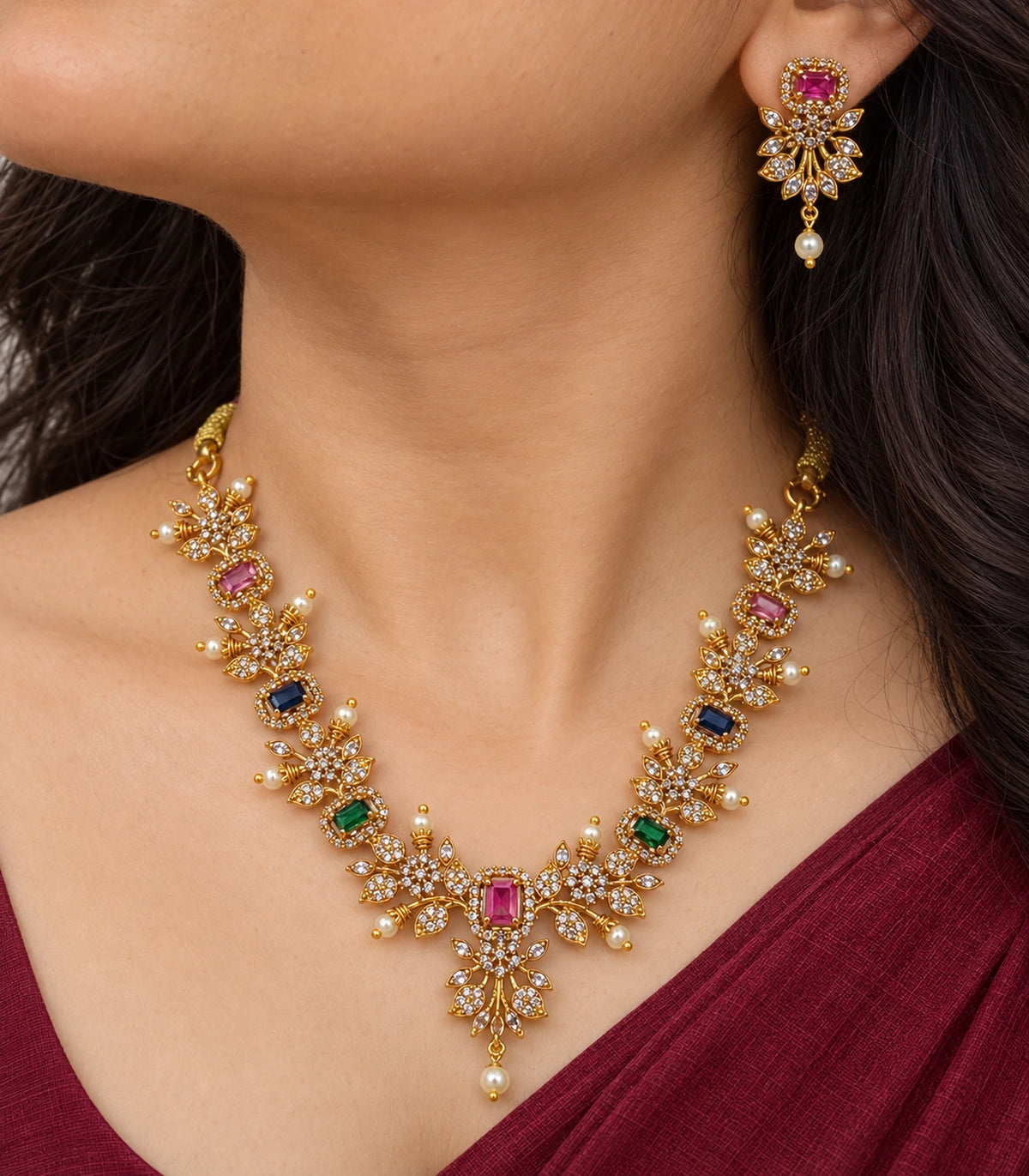 Close view of the multicolor floral necklace and matching pearl-drop earring worn naturally