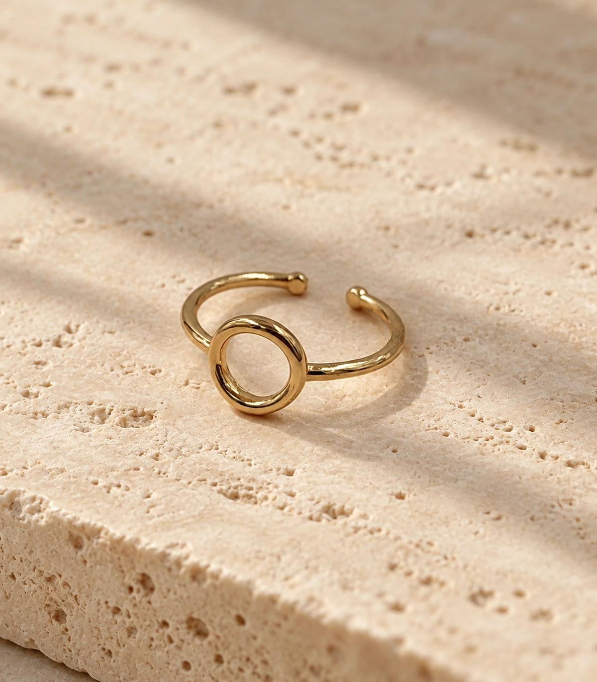 Complete Gold Open Circle Minimal Ring on a textured neutral stone surface
