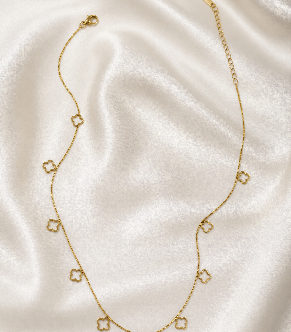 Gold Open Clover Charm Necklace styled in a flat lay