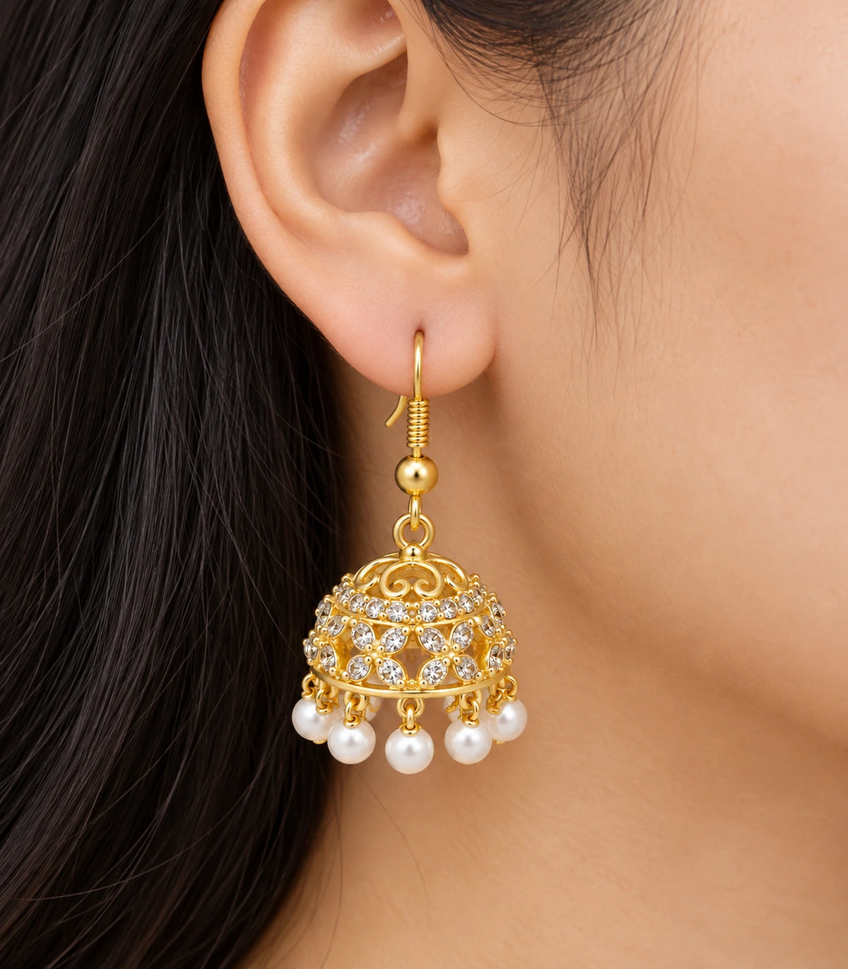 JIMIKI Gold Openwork Floral Crystal Jhumka Earrings - Worn close-up of floral openwork bell and hook #color_gold
