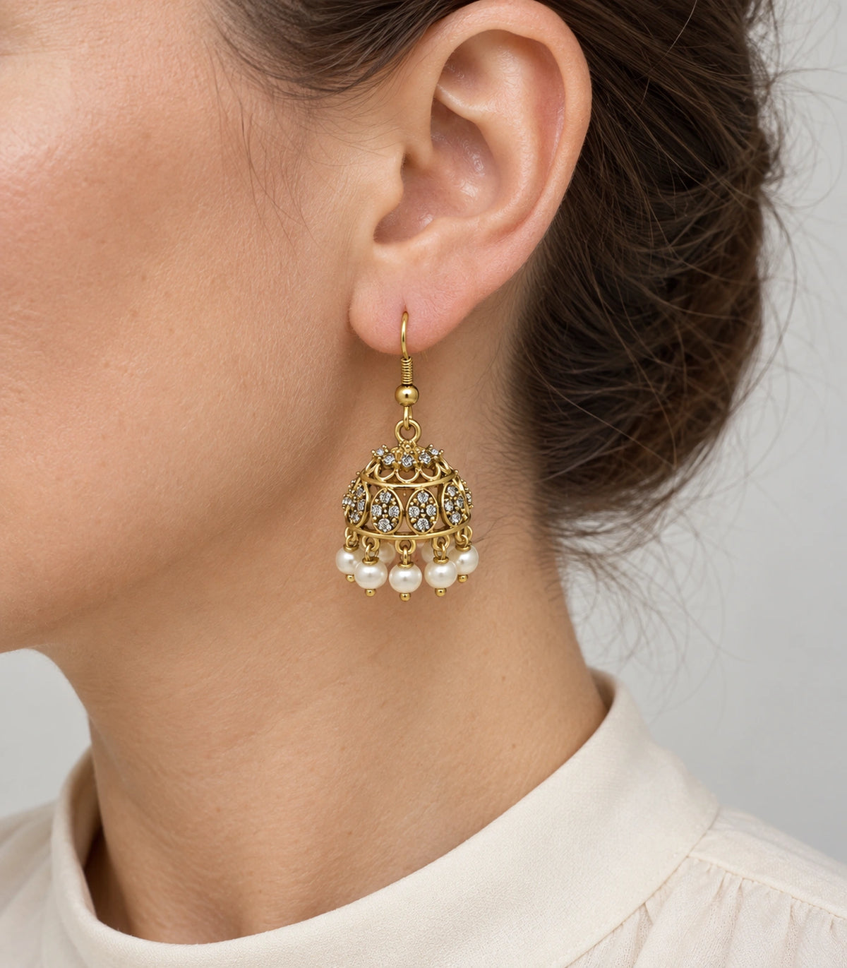 JIMIKI Gold Oval Crystal Pearl Hook Jhumka Earrings - Gold earring worn by a model #color_gold