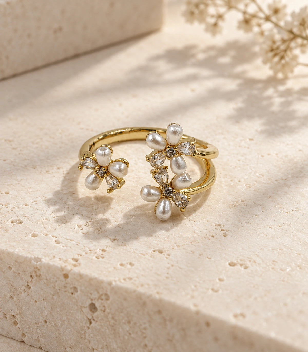 Single gold pearl crystal botanical open ring styled on pale stone