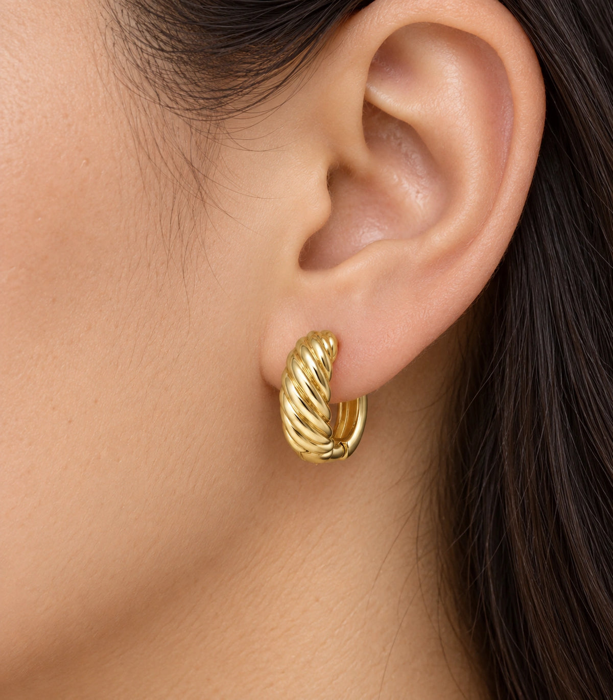 JIMIKI Twisted Rope Huggie Earrings in Gold Tone — worn close-up detail #color_gold-tone