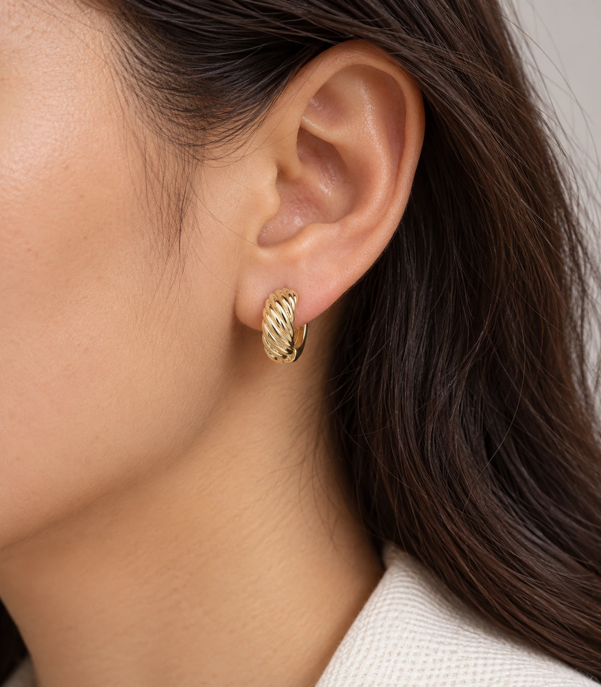 JIMIKI Twisted Rope Huggie Earrings in Gold Tone — worn styling view #color_gold-tone