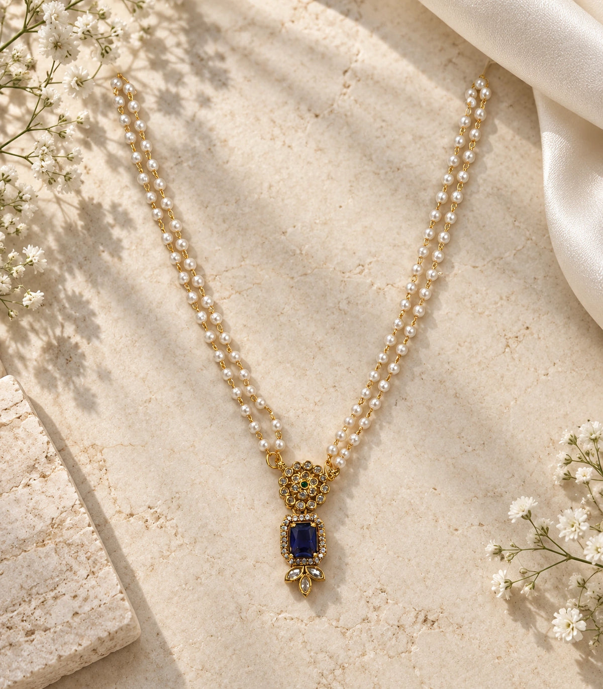 Gold Sapphire Kundan Double Pearl Necklace arranged on a stone surface